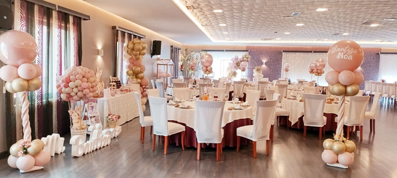 Salón completo decorado con globos rosas y dorados para un bautizo