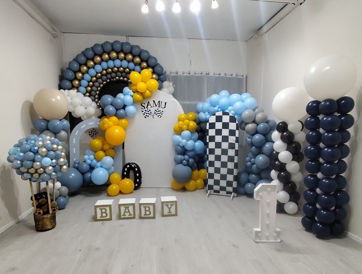 Decoración temática de carreras con arco de globos azul y dorado para primer cumpleaños