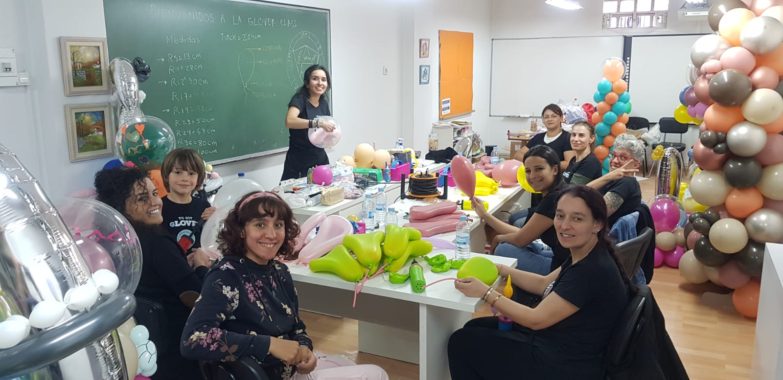 Carolina explicando la teoría de medidas en la pizarra de La Glover Class, rodeada de alumnas