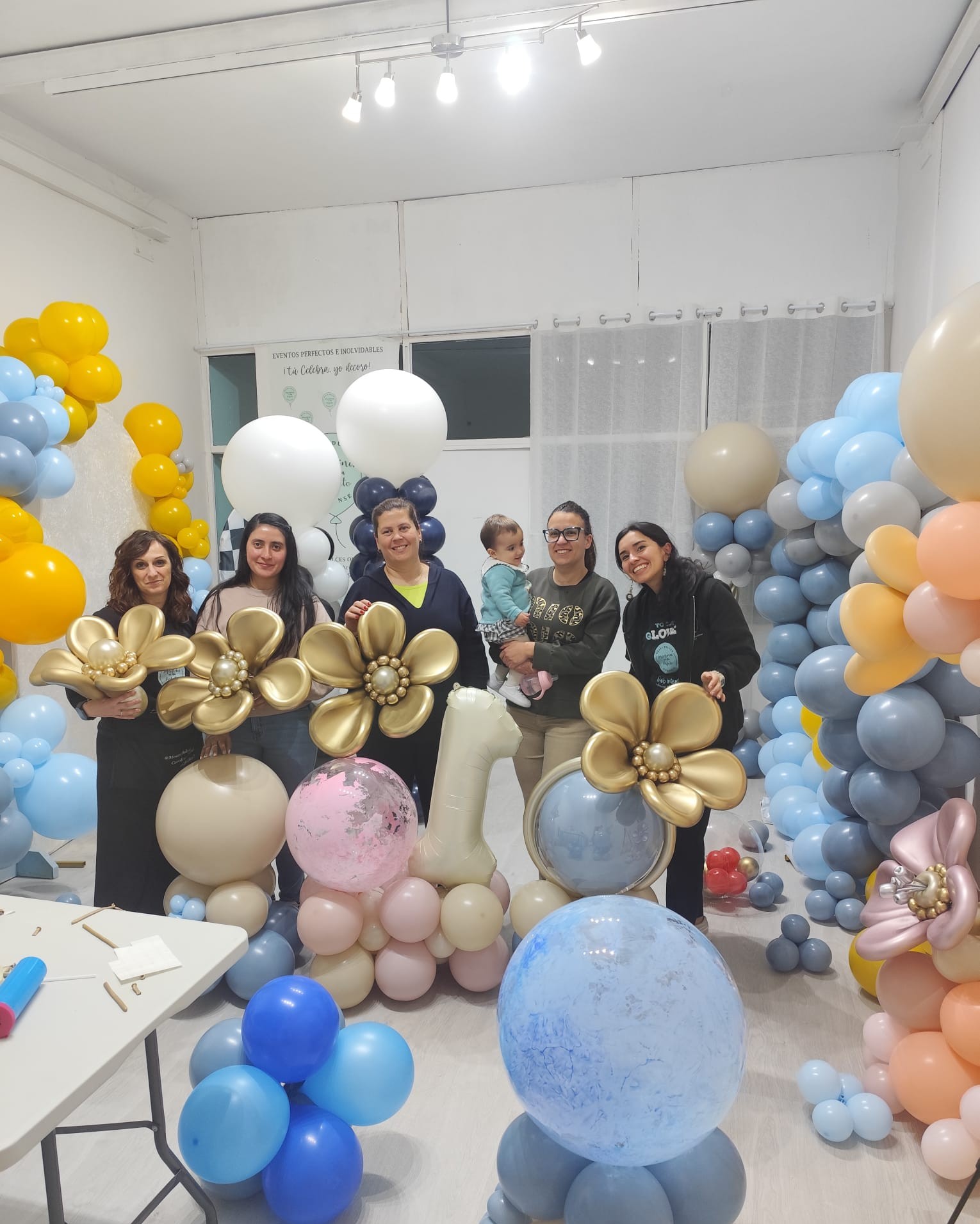Decoración de globos azul y dorada para bautizo junto al equipo Glover