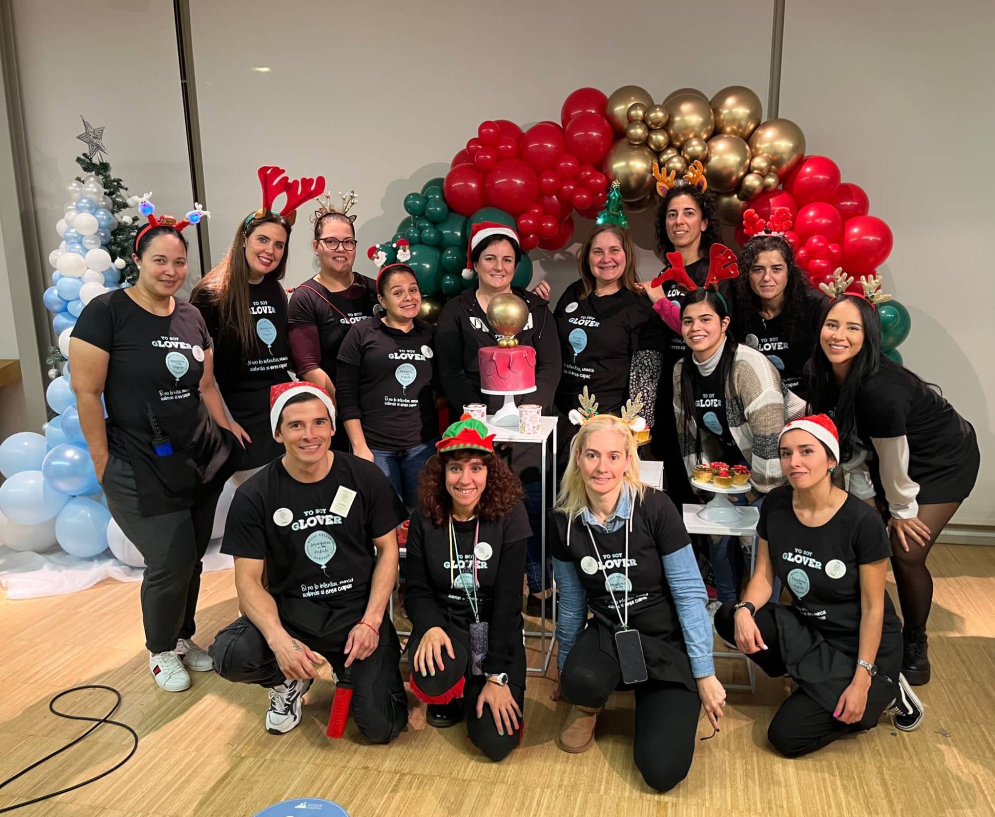 Alumnas y equipo Glover junto a un arco de globos navideño
