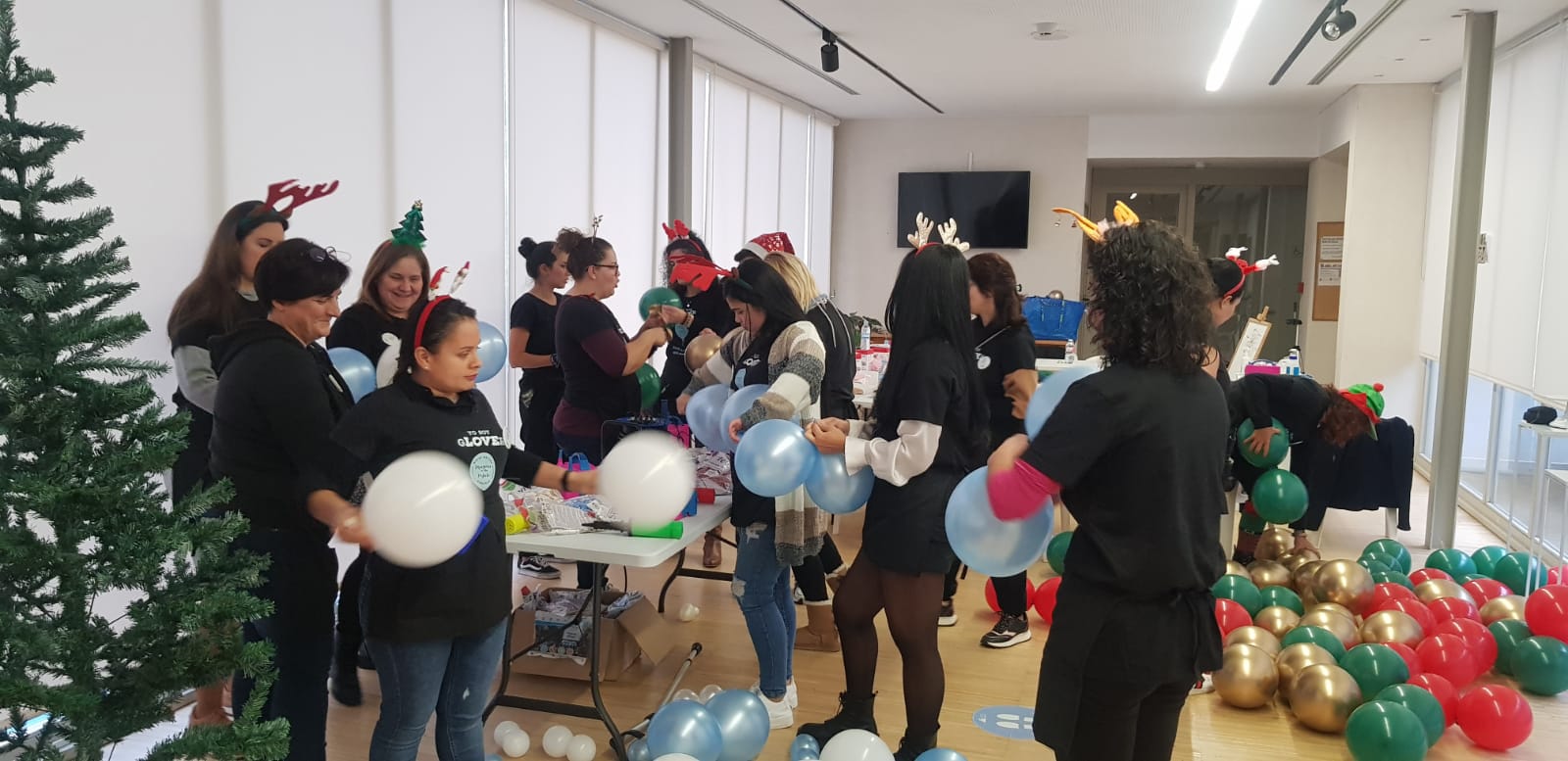Alumnas practicando con globos junto a un árbol de Navidad